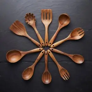Nine-piece natural teak wood kitchen utensils set including spoons, spatulas, and a ladle