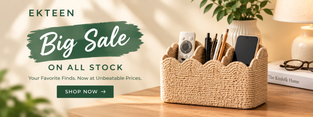 Ekteen storewide sale banner featuring a beige woven three-compartment organizer holding a remote control, smartphone, and pens on a wooden tabletop with natural home décor. Promotes a sale on all stock with a Shop Now call to action.