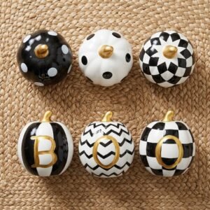 Set of six miniature black and white ceramic Halloween pumpkins with gold stems in polka dot, striped, chevron, harlequin, and checkerboard patterns, with gold letters spelling BOO